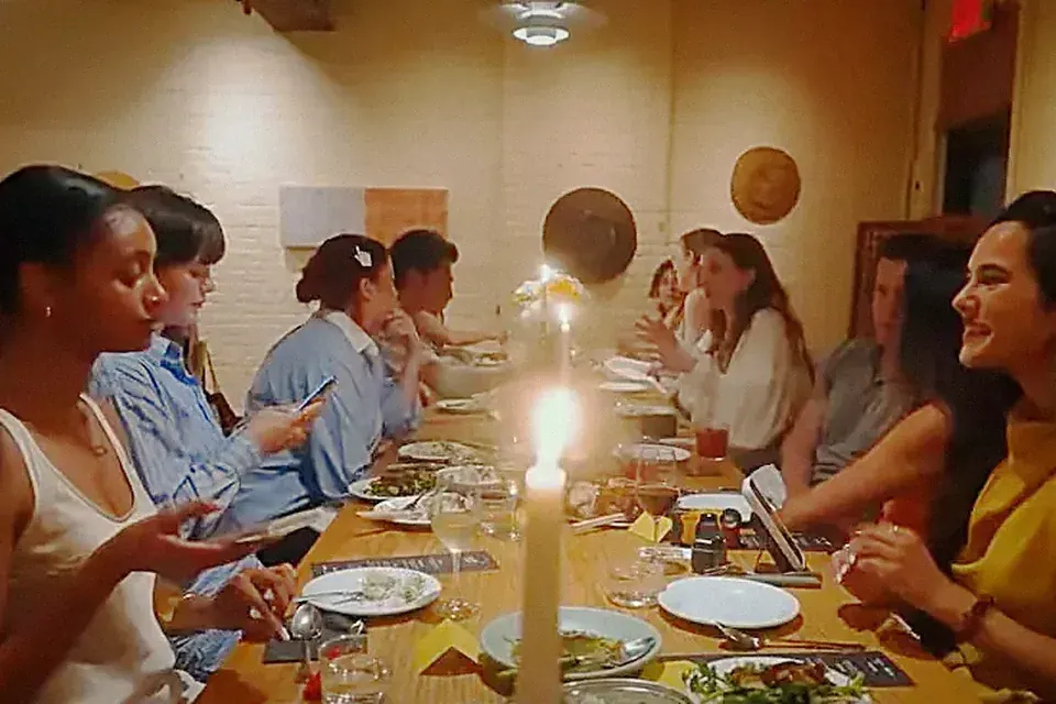 Creators around a long table at a candlelit creator dinner