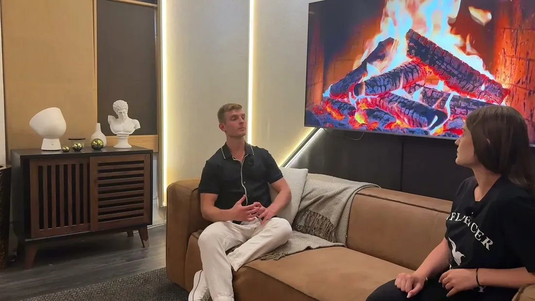 Dennis and Alice talking on the couch at the studio